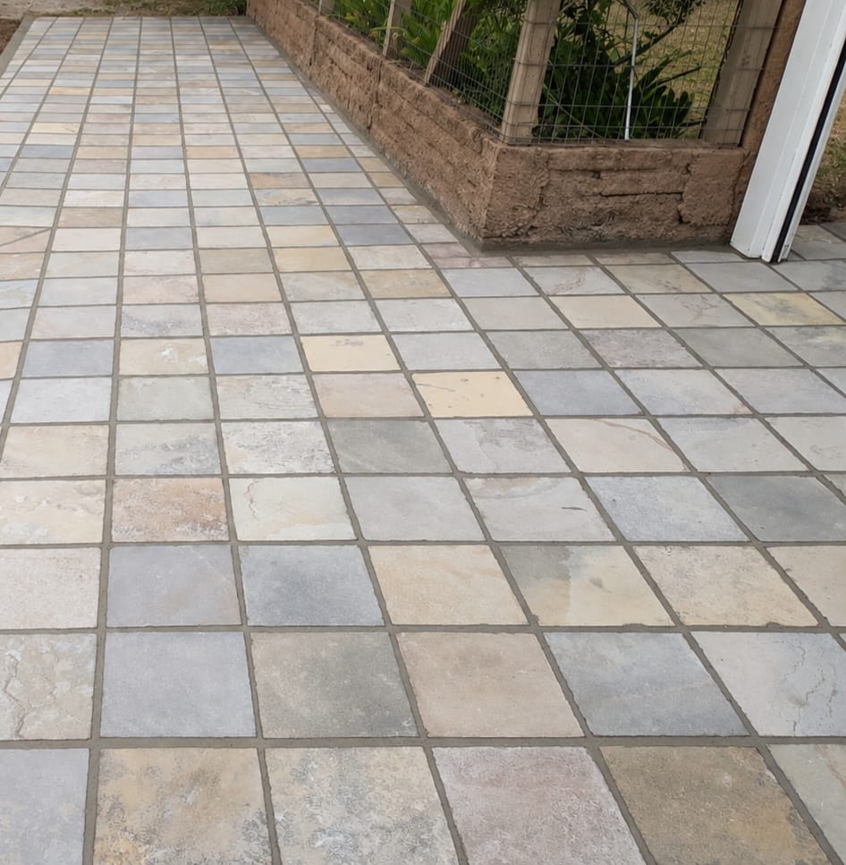 Piso externo em placas de pedra com paginação quadrada