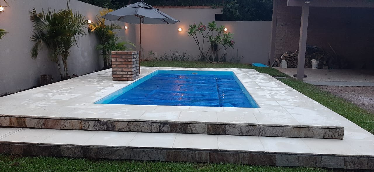 Piscina com borda e degraus claros em ambiente paisagístico