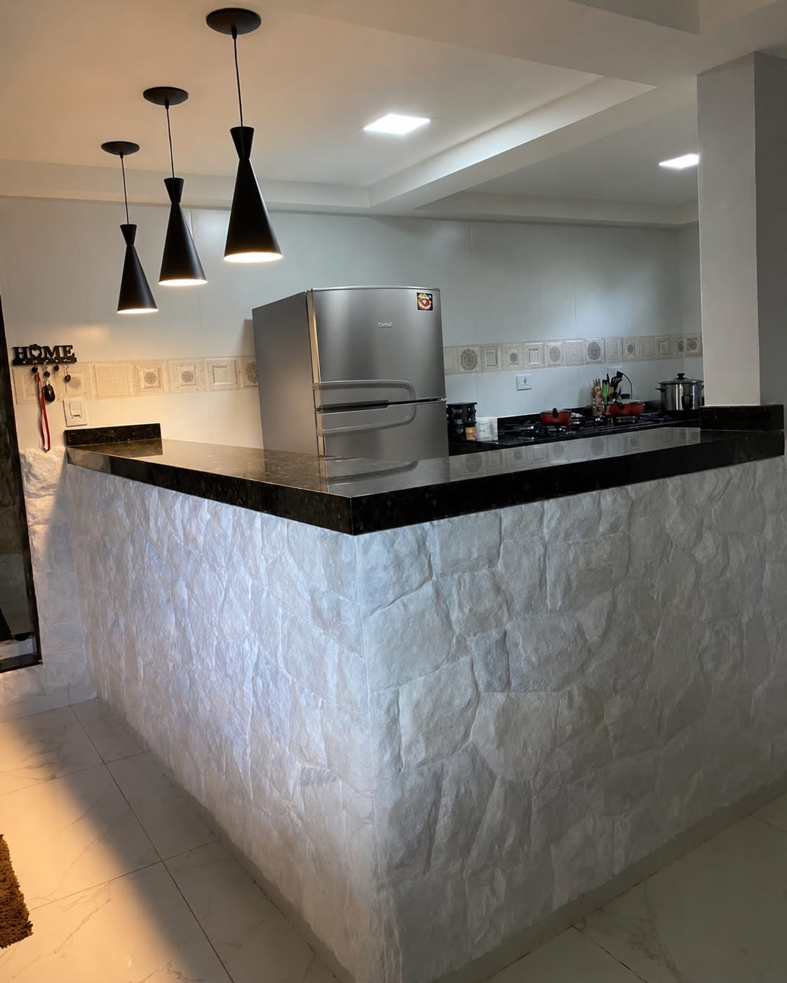 Bancada de cozinha revestida em pedra natural clara